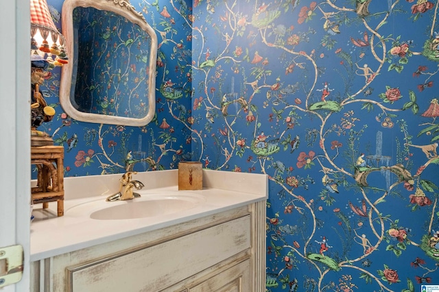 bathroom with wallpapered walls and vanity