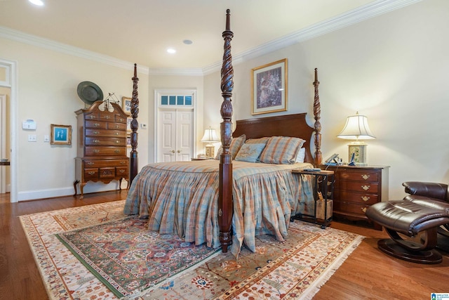 bedroom with crown molding, wood finished floors, recessed lighting, a closet, and baseboards