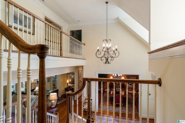 stairway with a towering ceiling, a chandelier, crown molding, and baseboards