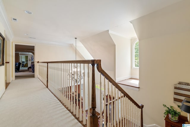 hallway featuring crown molding, baseboards, and light carpet