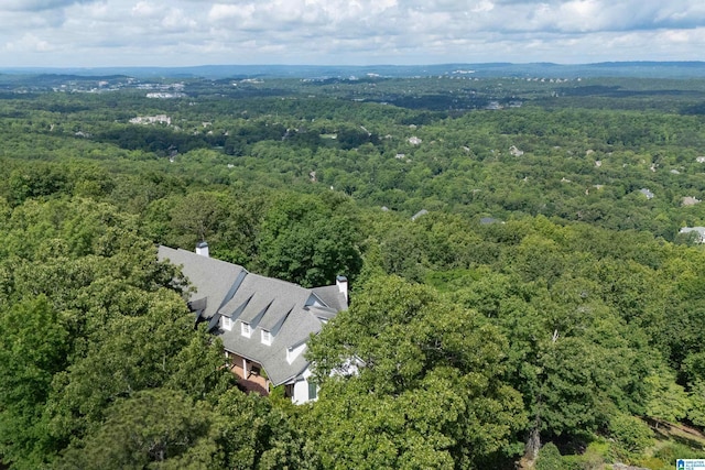 aerial view of property and surrounding area featuring a heavily wooded area