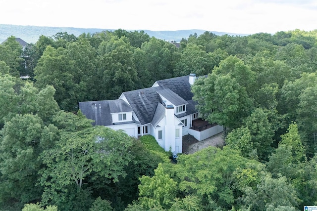 aerial view of property and surrounding area featuring a forest