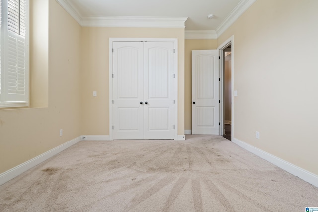 unfurnished bedroom featuring crown molding, a closet, carpet, and baseboards