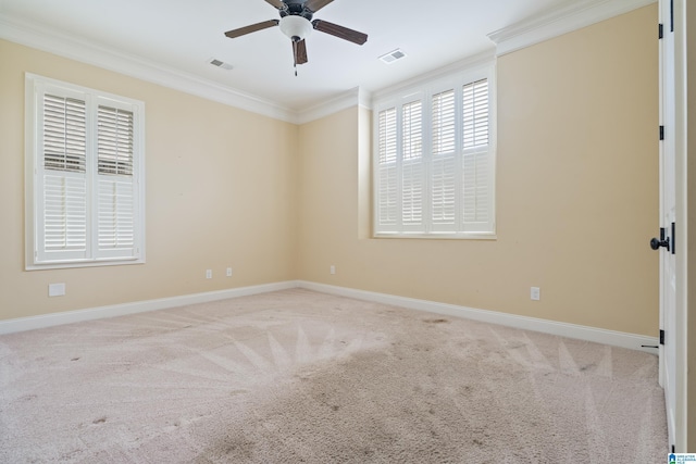 carpeted empty room featuring ornamental molding, a ceiling fan, and baseboards