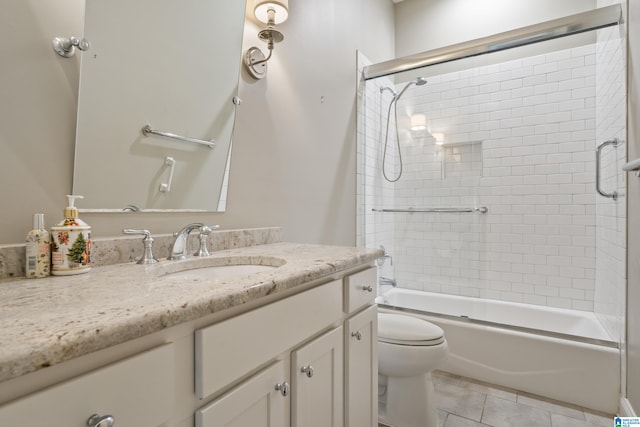 bathroom with toilet, vanity, tile patterned floors, and shower / bath combination with glass door