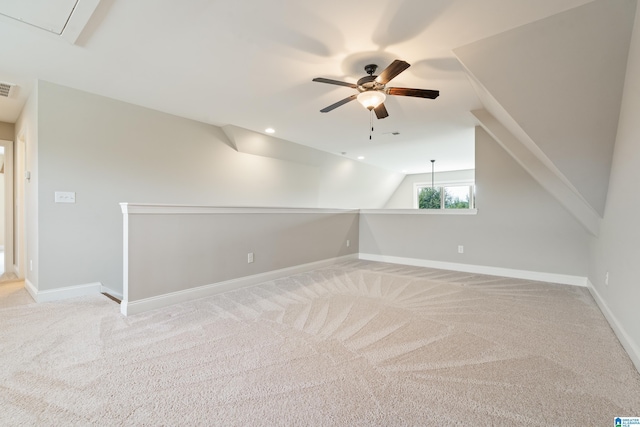 additional living space with a ceiling fan, light carpet, baseboards, attic access, and lofted ceiling