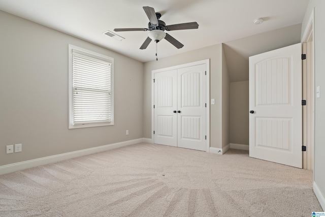 unfurnished bedroom with a closet, carpet floors, baseboards, and ceiling fan