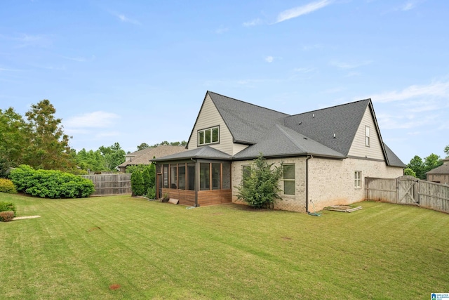 back of property featuring a sunroom, brick siding, roof with shingles, and a gate