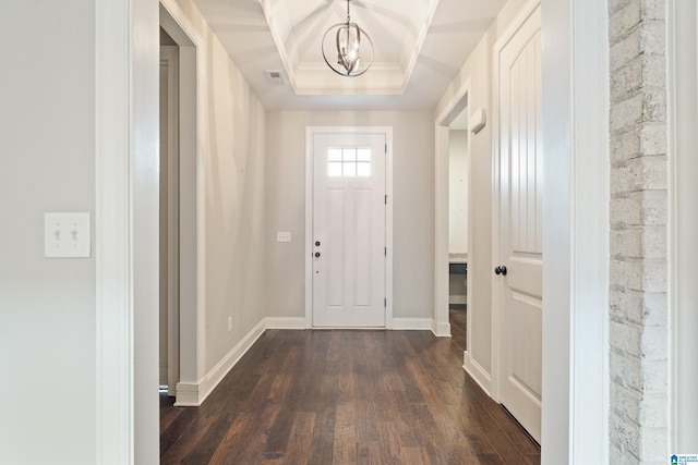 foyer featuring dark wood finished floors, a chandelier, a raised ceiling, and baseboards