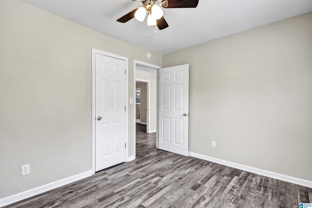 unfurnished bedroom with wood finished floors, baseboards, and a ceiling fan
