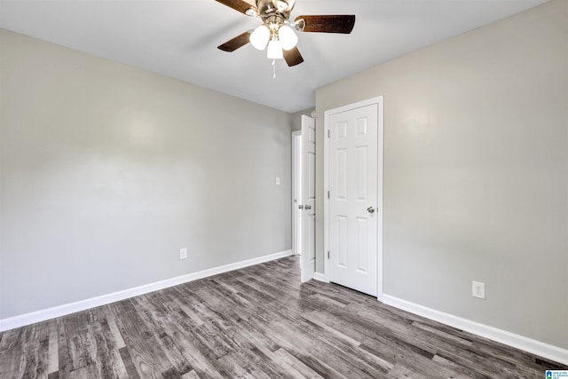 spare room with wood finished floors, baseboards, and a ceiling fan