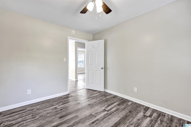 unfurnished room featuring wood finished floors, baseboards, ceiling fan, and a smoke detector