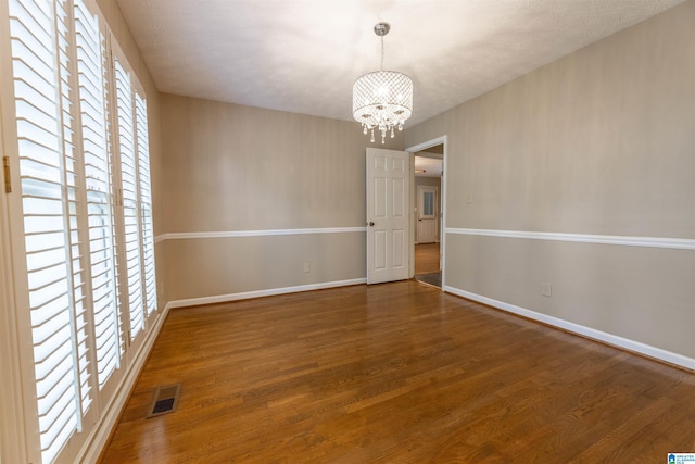994 Comanche Trl, Anniston, AL 36206 - unfurnished room with a chandelier, wood finished floors, and baseboards