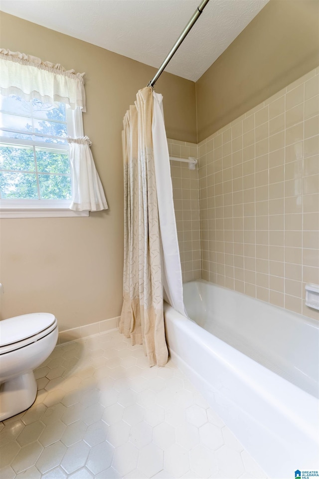994 Comanche Trl, Anniston, AL 36206 - full bath featuring toilet, tile patterned floors, and shower / bath combination with curtain