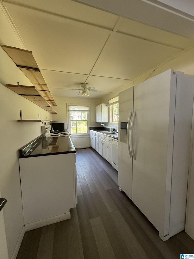 829 Higgs Dr, Adger, AL 35006 - kitchen with white appliances, white cabinets, dark countertops, a sink, and dark wood finished floors