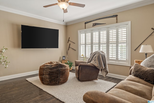 living area with baseboards, a ceiling fan, wood finished floors, and crown molding