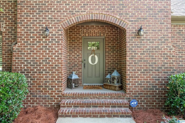 doorway to property with brick siding