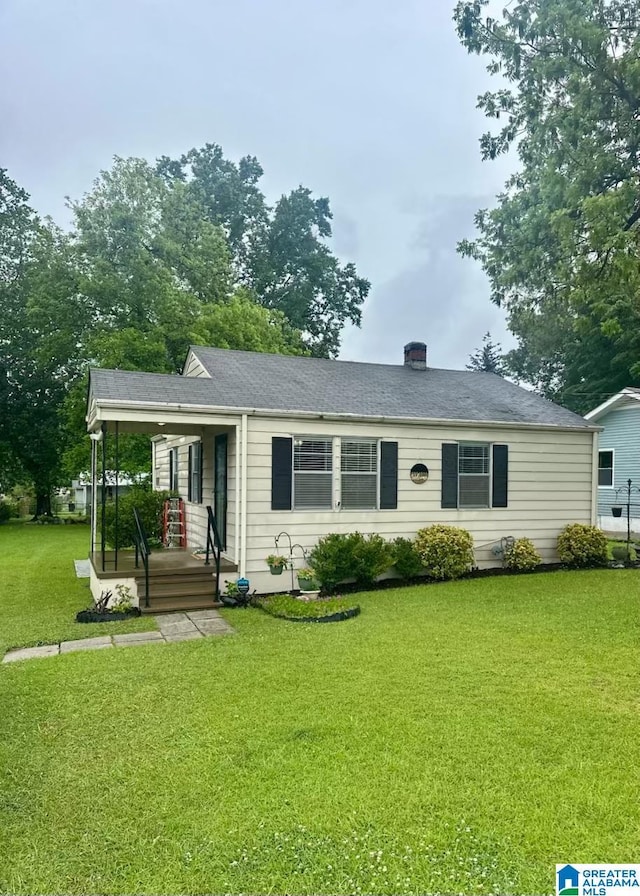 single story home featuring a front yard, a porch, and a chimney