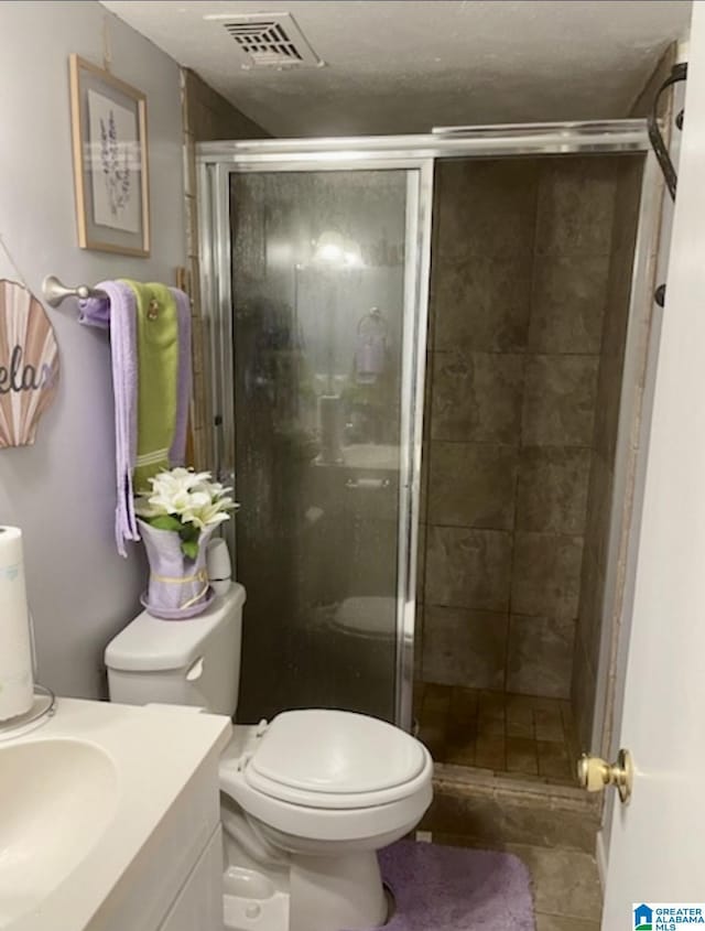 906 30th St, Phenix City, AL 36867 - bathroom featuring a shower stall, toilet, vanity, and tile patterned flooring