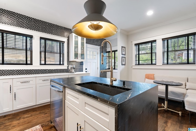 kitchen with stainless steel dishwasher, dark wood-style flooring, crown molding, dark stone countertops, and glass insert cabinets