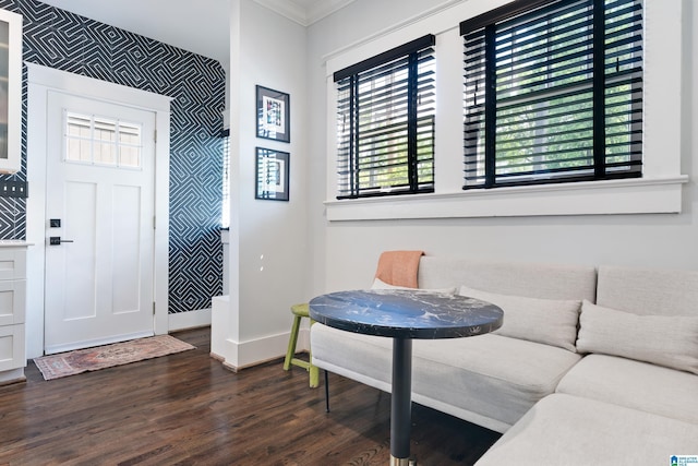 entryway featuring wallpapered walls, baseboards, dark wood-style floors, an accent wall, and ornamental molding