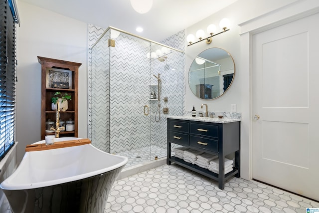 bathroom featuring a shower stall, vanity, and a freestanding bath