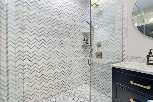 bathroom featuring a walk in shower, vanity, and a decorative wall