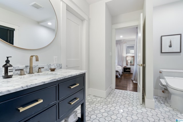 ensuite bathroom featuring toilet, baseboards, vanity, recessed lighting, and tile patterned flooring