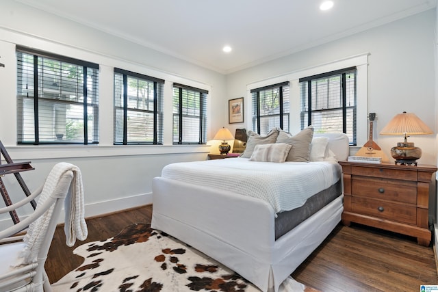 bedroom with dark wood-type flooring, crown molding, recessed lighting, and baseboards