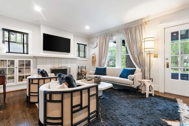 living room with dark wood-type flooring, crown molding, a fireplace, and recessed lighting
