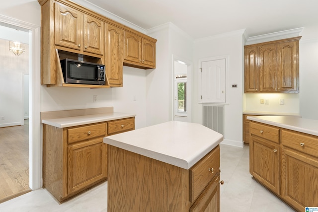 175 Sunhill Rd, Remlap, AL 35133 - kitchen featuring stainless steel microwave, light countertops, brown cabinets, crown molding, and a kitchen island