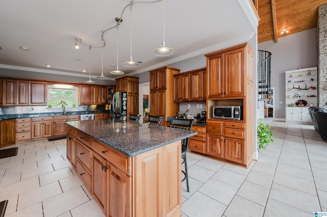 327 Ridgeview Lake Rd, Alabaster, AL 35007 - kitchen with stainless steel appliances, brown cabinetry, a kitchen bar, light tile patterned floors, and a center island