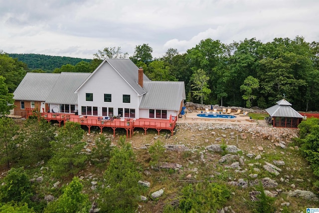 327 Ridgeview Lake Rd, Alabaster, AL 35007 - back of property featuring metal roof, an outdoor pool, a wooden deck, and a forest view