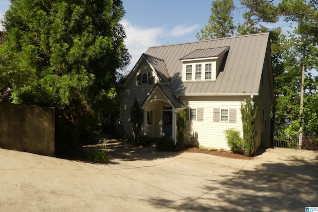 view of front of property with fence, a standing seam roof, and metal roof