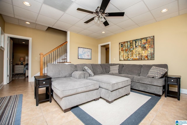 living area featuring stairs, ceiling fan, light tile patterned floors, a drop ceiling, and recessed lighting