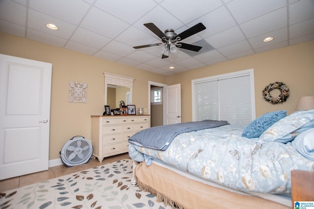 bedroom featuring light tile patterned flooring, a paneled ceiling, recessed lighting, ceiling fan, and a closet