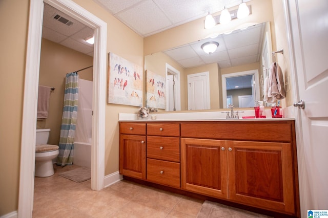 full bath with a drop ceiling, toilet, vanity, tile patterned flooring, and shower / bath combo with shower curtain
