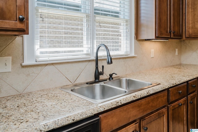 kitchen featuring a sink, decorative backsplash, and dishwashing machine