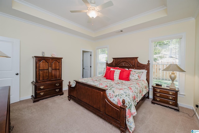 bedroom with a raised ceiling, light carpet, crown molding, baseboards, and ceiling fan