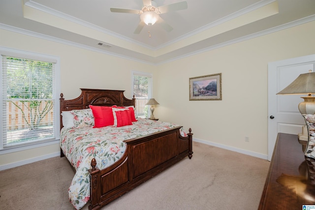 bedroom with a tray ceiling, light carpet, baseboards, and crown molding