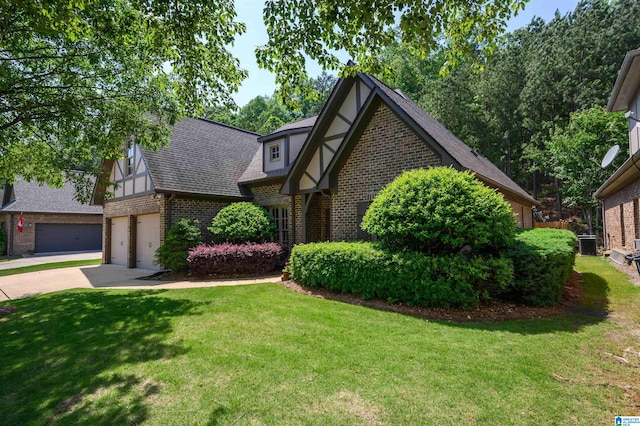 tudor home featuring brick siding, roof with shingles, a front lawn, and concrete driveway