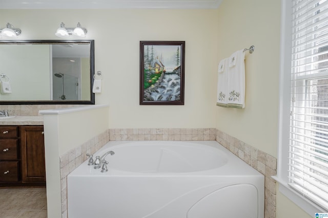 full bath featuring healthy amount of natural light, vanity, a bath, and tile patterned floors