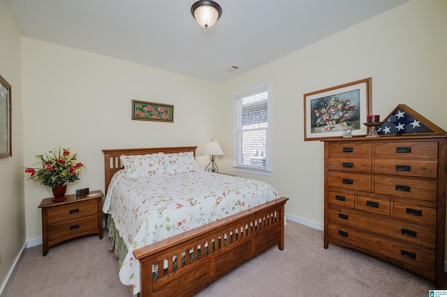 bedroom featuring light carpet and baseboards