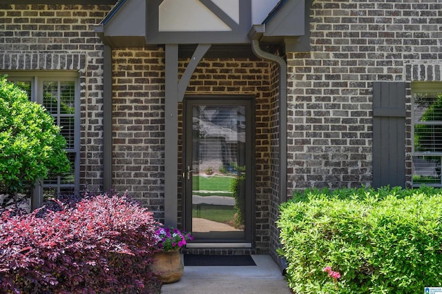 doorway to property featuring brick siding