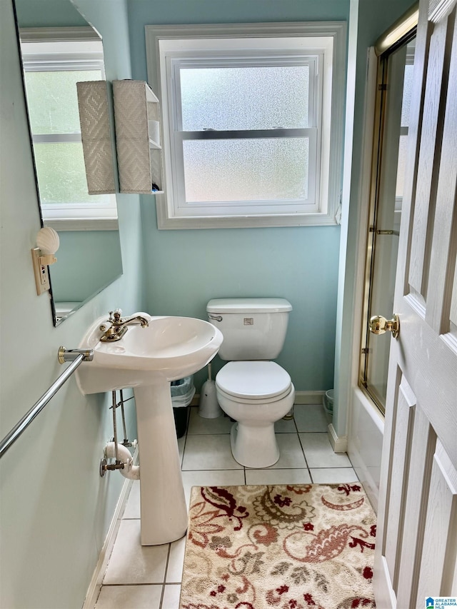 full bathroom featuring tile patterned flooring, toilet, baseboards, and shower / washtub combination