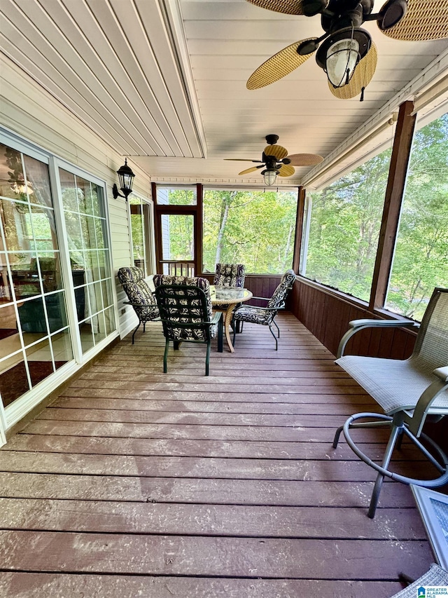 sunroom / solarium featuring outdoor dining area, ceiling fan, and healthy amount of natural light