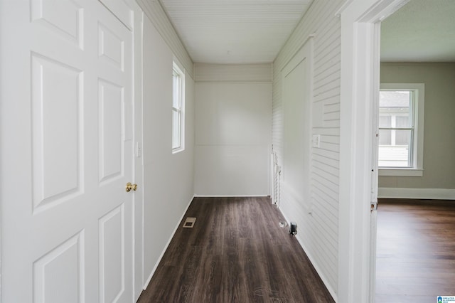 corridor featuring dark wood finished floors and baseboards