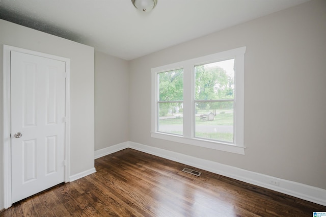 unfurnished bedroom featuring baseboards and dark wood-style flooring