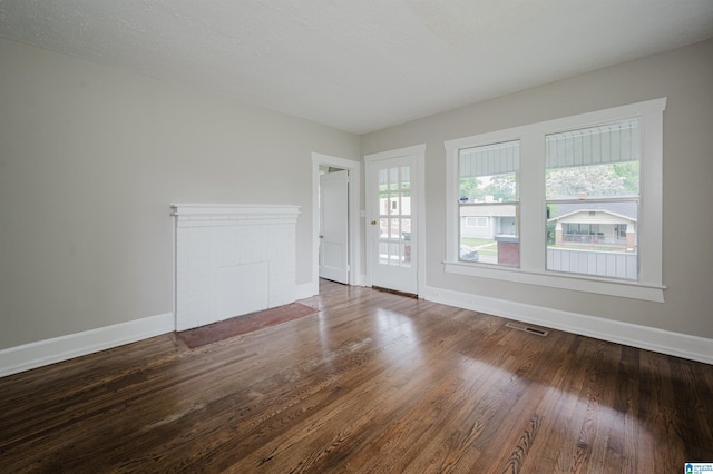 unfurnished living room featuring baseboards and wood finished floors
