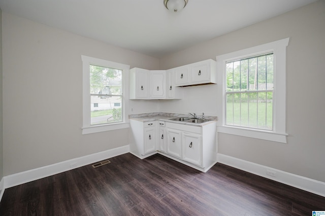 kitchen with a sink, dark wood-style flooring, baseboards, light countertops, and white cabinetry